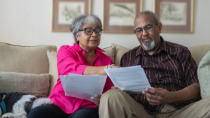 Close-up of a senior couple reading an official-looking mailed notice Annual Notice of Change.